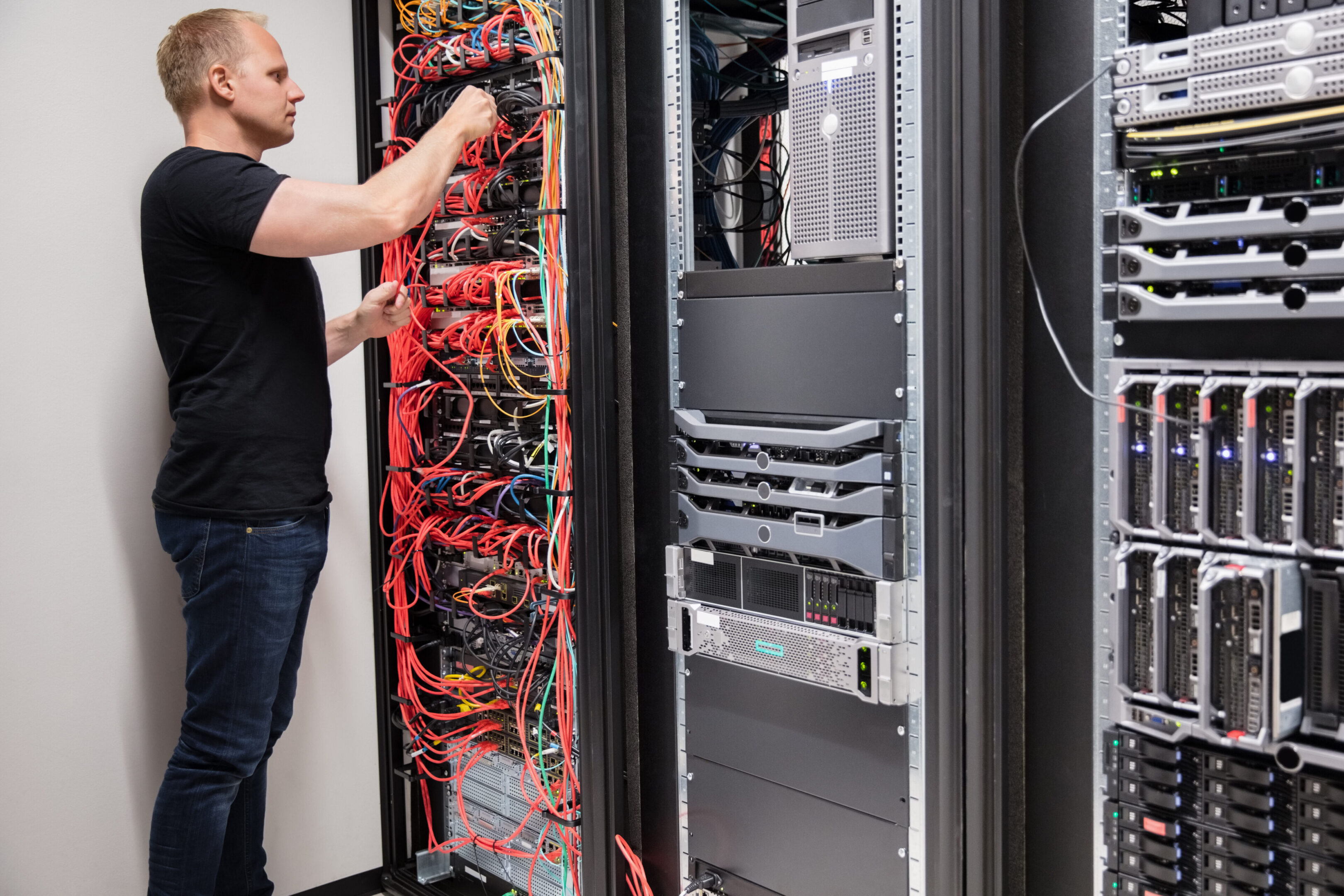 A man standing in front of some wires and cables.